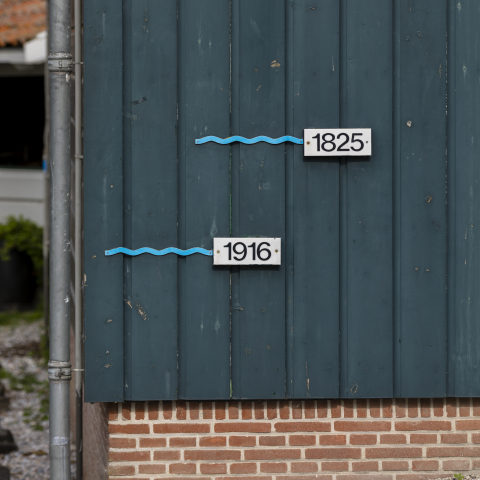 Op de gevel is te zien hoe hoog het water ooit kwam